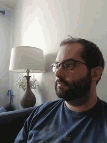 a man with glasses and a beard is laying down