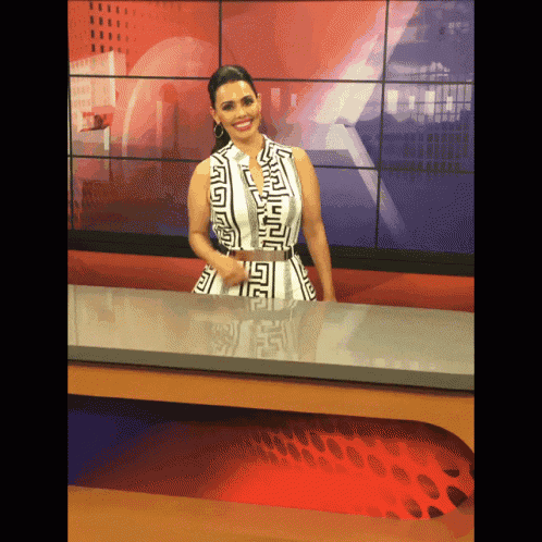 a woman in a black and white dress is standing in front of a red background