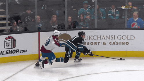 a hockey game is being played in front of an ad for ukchassi gold