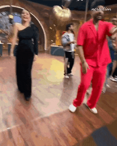 a man and a woman are dancing together on a wooden floor .