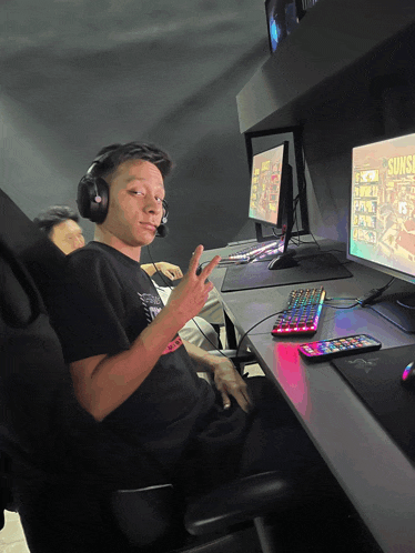 a man wearing headphones sits in front of a computer monitor that says sunset