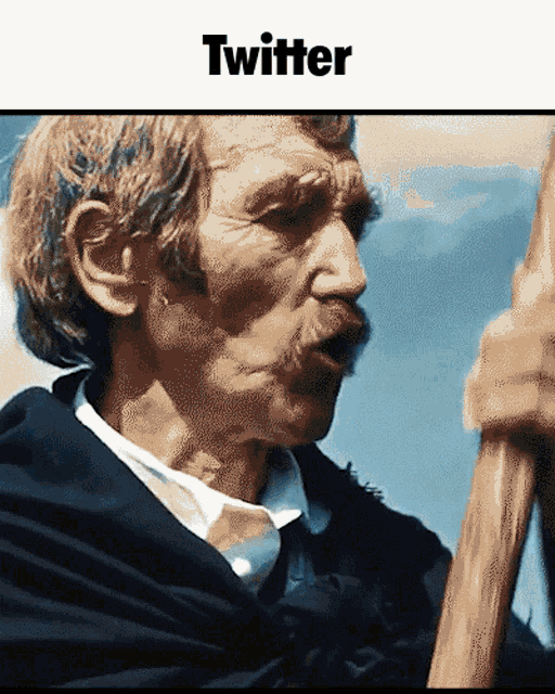 a man with a mustache is holding a stick in front of a twitter banner