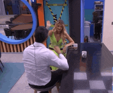 a man and a woman are sitting at a table talking to each other .