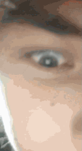 a close up of a person 's eye with a blurred background
