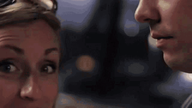 a close up of a man and woman kissing each other .