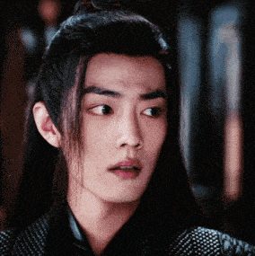 a close up of a young man with long hair