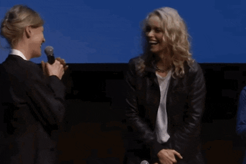 two women are standing next to each other with microphones in their hands