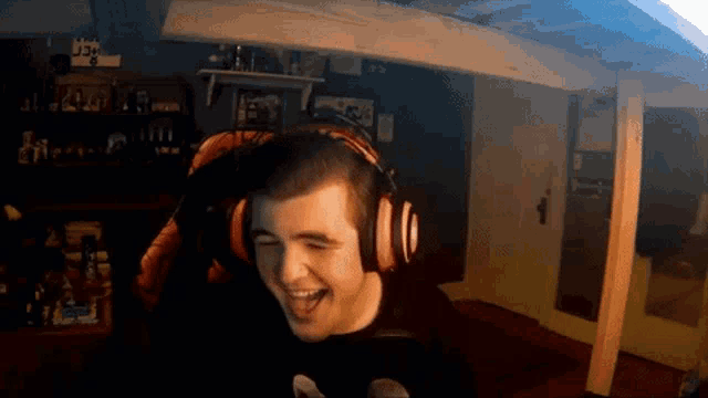 a man wearing headphones is laughing in a room with a sign that says j3 on it