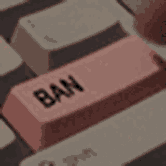 a close up of a computer keyboard with a pink button that says ban .