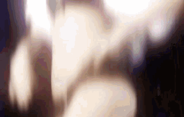 a blurry picture of a person 's face with a purple background .