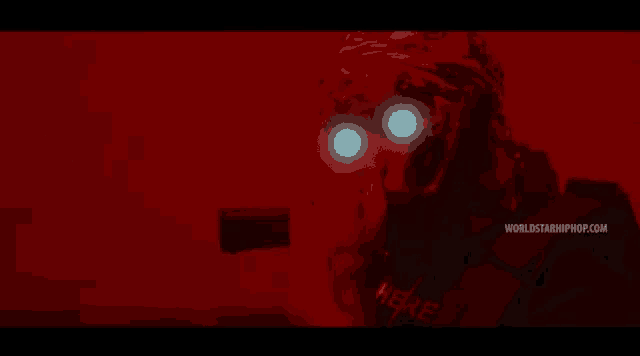 a person with glowing eyes is wearing a shirt that says here on it