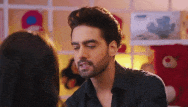 a man with a beard is looking at a woman .