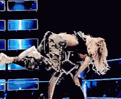 a woman is being lifted in the air by a man in a wrestling ring .