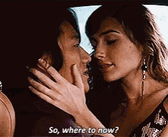 two women are kissing in a car and one of them is asking the other where to go now .