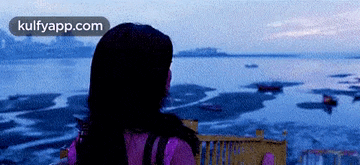 a woman is looking out over a body of water with the words kulfyapp.com visible in the corner