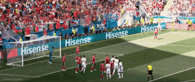 a soccer game is being played in front of a banner that says hisense on it