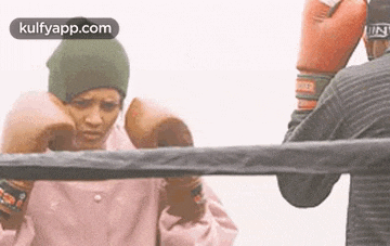 a man and a woman are boxing in a ring .