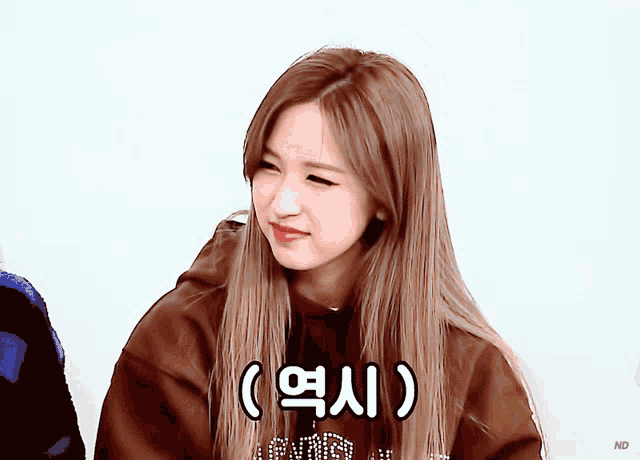 a woman wearing a brown hoodie with chinese writing on the front