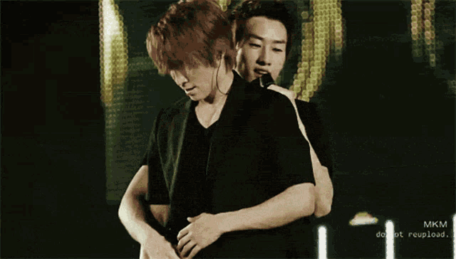 a picture of two men hugging with the words mkm do not reupload