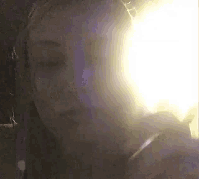 a close up of a woman 's face with a light coming out of her eyes .