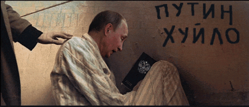 a man is reading a book in front of a wall that says " putin "