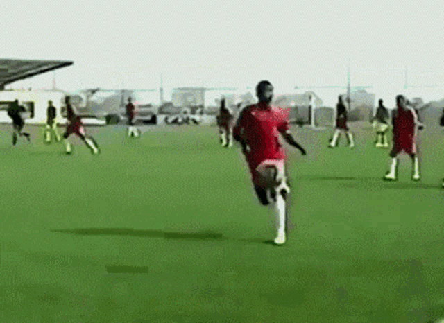 a group of people are playing soccer on a field and one of them is wearing a red shirt with the number 31 on it