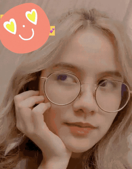 a girl wearing glasses has a smiley face on her head
