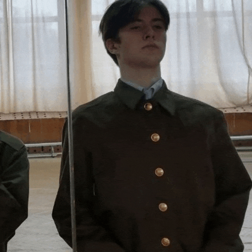 a man in a military uniform is standing in front of a mirror