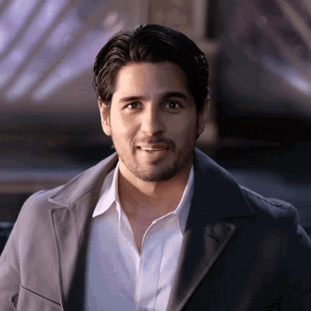 a man with a beard wearing a grey jacket and white shirt