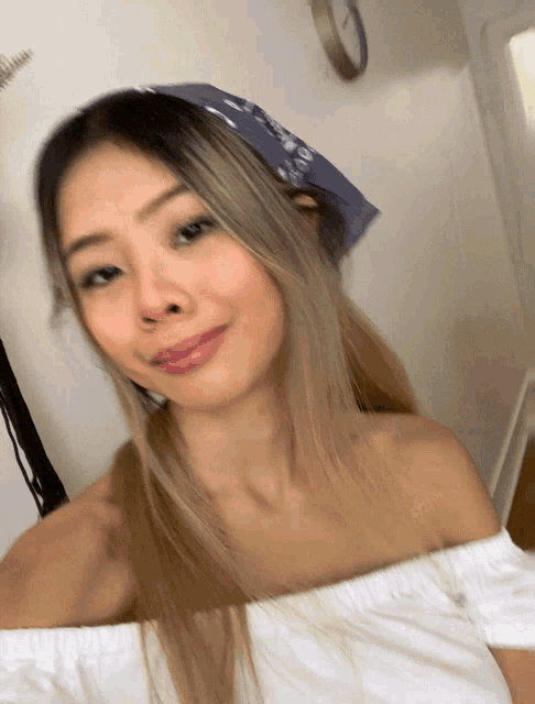 a woman taking a selfie with a blue bandana on her head