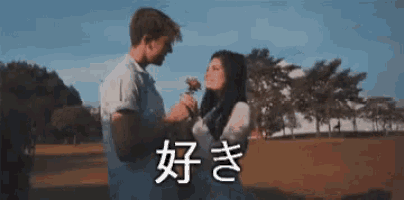 a man is giving a rose to a woman in a park in a foreign language .