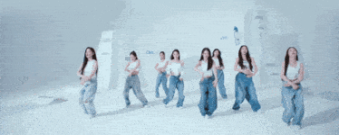 a group of women are dancing in a room with the word love on the wall