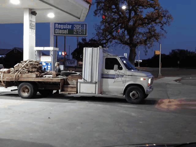 a white truck is parked in front of a gas station that sells regular diesel