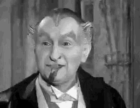 a man with horns painted on his face is smoking a cigar .