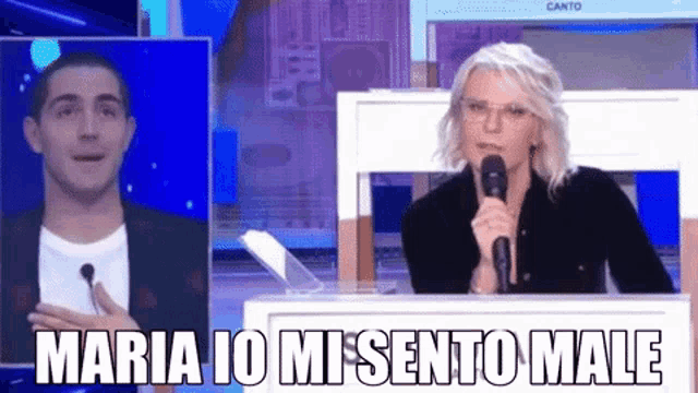 a woman speaking into a microphone next to a man with the words maria io mi sento male above her