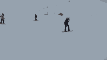 a snowboarder wearing a fur hood and goggles stands in the snow