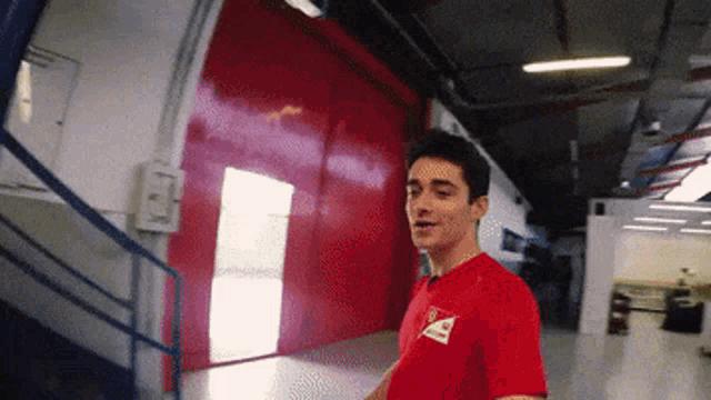 a man wearing a red shirt with a white triangle on it
