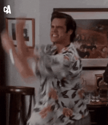 a man in a hawaiian shirt is dancing in front of a painting .