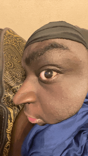a man wearing a headband and a blue scarf looks at the camera