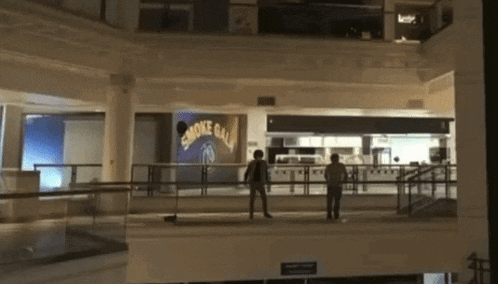 two people standing in front of a sign that says " smoke ball "