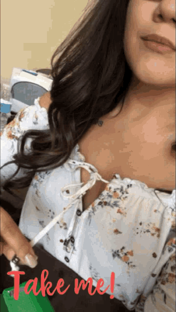 a woman wearing a white floral top with the words take me written in red