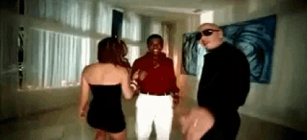 a man and two women are standing in a room talking to each other .