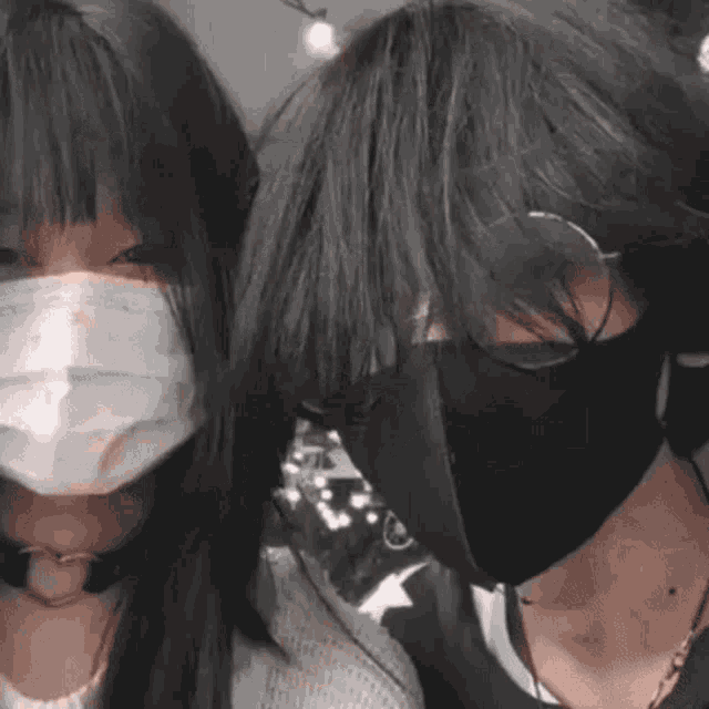 a man and a woman wearing face masks and sunglasses .