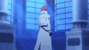 a man in a white coat and red hair is standing in front of a window in a room .