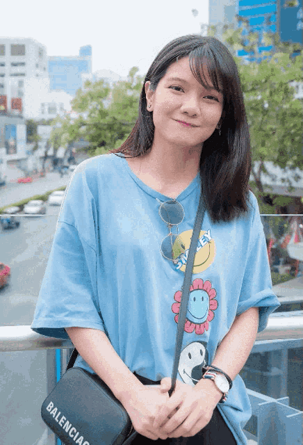a woman wearing a blue shirt with smiley faces on it