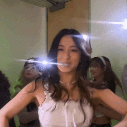 a woman in a white top is taking a selfie