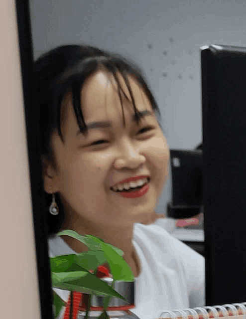 a woman is smiling while looking at a computer screen