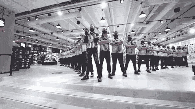 a group of referees are standing in a line with their arms outstretched