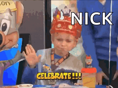 a young boy wearing a crown is sitting at a table with a chuck e cheese mascot .