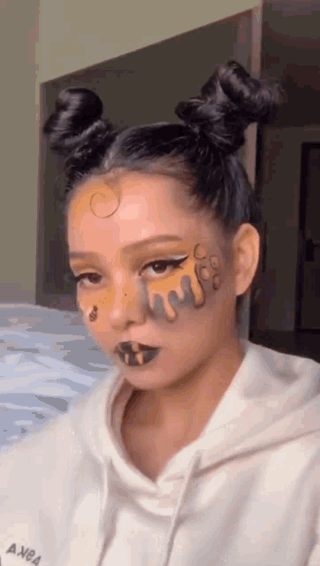 a woman with two buns on her hair and face paint .